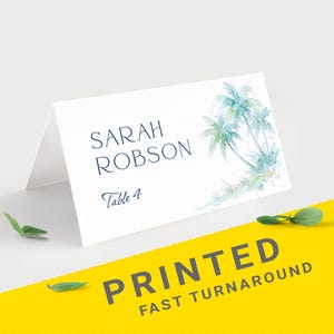Pu&ograve; includere: Biglietto da tavolo bianco con il nome "Sarah Robson" e "Table 4" stampati in blu navy. Il biglietto presenta un design ad acquerello di palme nei toni del blu e del verde. Le parole "PRINTED FAST TURNAROUND" sono stampate su sfondo giallo.