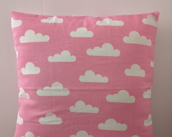 Housse de coussin rose avec des nuages blancs