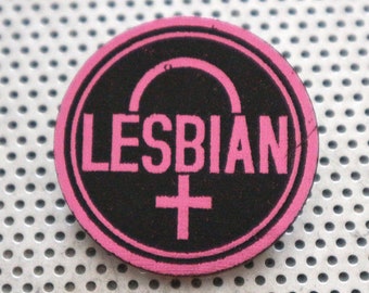 May include: Pink and black round patch with the word "LESBIAN" in pink letters and a pink female symbol.