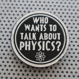 May include: A black and white round button with the text "Who wants to talk about physics?" and an atom symbol.