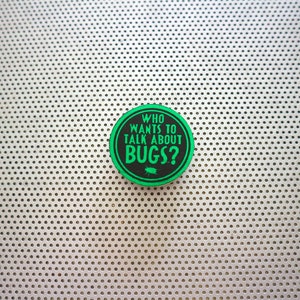 May include: A green and black round sticker with the text "WHO WANTS TO TALK ABOUT BUGS?" on a white background with a pattern of small holes.