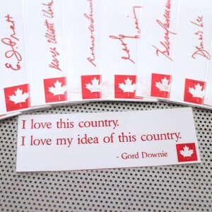 May include: A white card with red text and a red Canadian flag. The text reads "I love this country. I love my idea of this country. - Gord Downie"