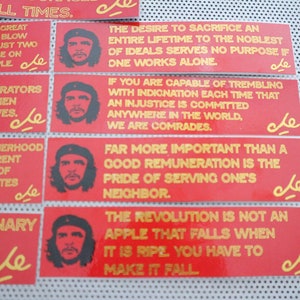 May include: Eight red and yellow stickers with a portrait of Che Guevara and a quote in gold lettering. The quotes are: "At all times", "The moment the great", "Liberator, liberators", "What our brotherhood", "Revolutionary, a great", "The desire to sacrifice", "If you are capable", "Far more important".