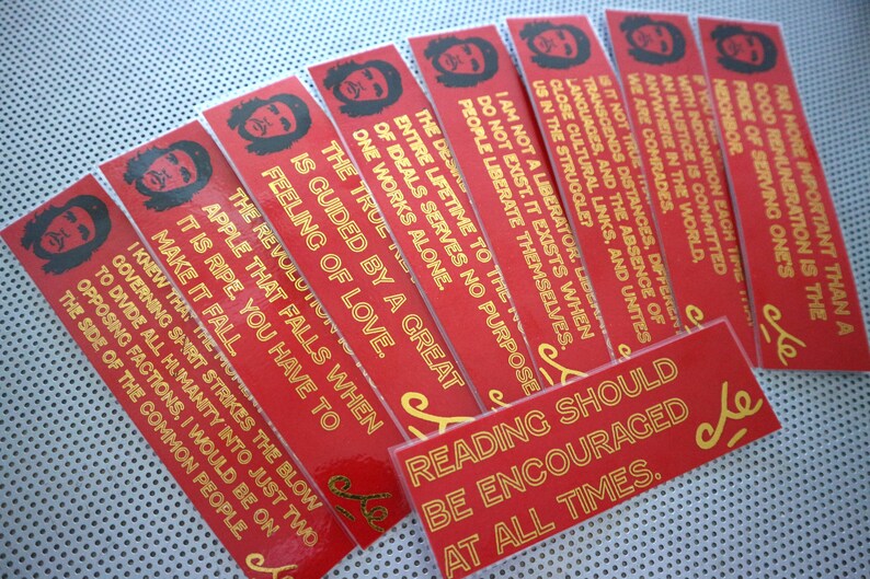 May include: A set of ten red bookmarks with gold text featuring quotes from Che Guevara. The bookmarks feature a silhouette of Che Guevara's face.