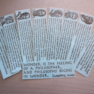 May include: A set of ten blue bookmarks featuring portraits of famous philosophers, including Socrates, Plato, and Aristotle. Each bookmark includes a quote from the philosopher and a brief biography. The quote on the bottom bookmark reads "Wonder is the feeling of a philosopher, and philosophy begins in wonder. - Socrates".