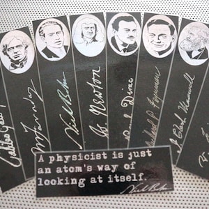 Puede incluir: Un conjunto de marcadores negros y blancos con retratos de físicos famosos con sus nombres escritos debajo. La cita "Un físico es solo una forma de un átomo de verse a sí mismo." está impresa en un rectángulo negro separado.