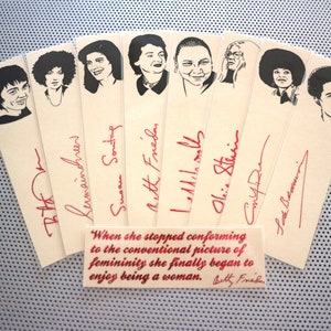 May include: A set of ten bookmarks featuring black and white illustrations of famous women with their names and signatures in red ink. The quote "When she stopped conforming to the conventional picture of femininity she finally began to enjoy being a woman. Betty Friedan" is printed on a separate bookmark.