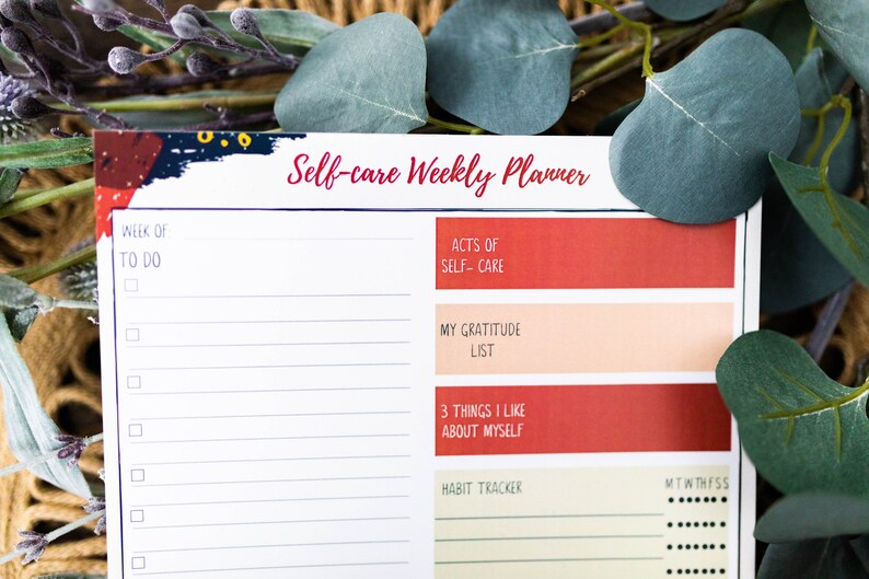 May include: A white self-care weekly planner with a colorful abstract design at the top. The planner includes sections for to-do lists, acts of self-care, a gratitude list, three things you like about yourself, and a habit tracker.