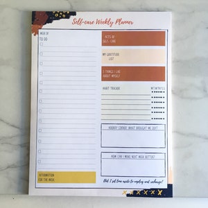 May include: A white self-care weekly planner with a brown and black abstract design. The planner includes sections for to-do lists, acts of self-care, gratitude, things you like about yourself, a habit tracker, a hooray corner, how to make next week better, and an affirmation for the week.