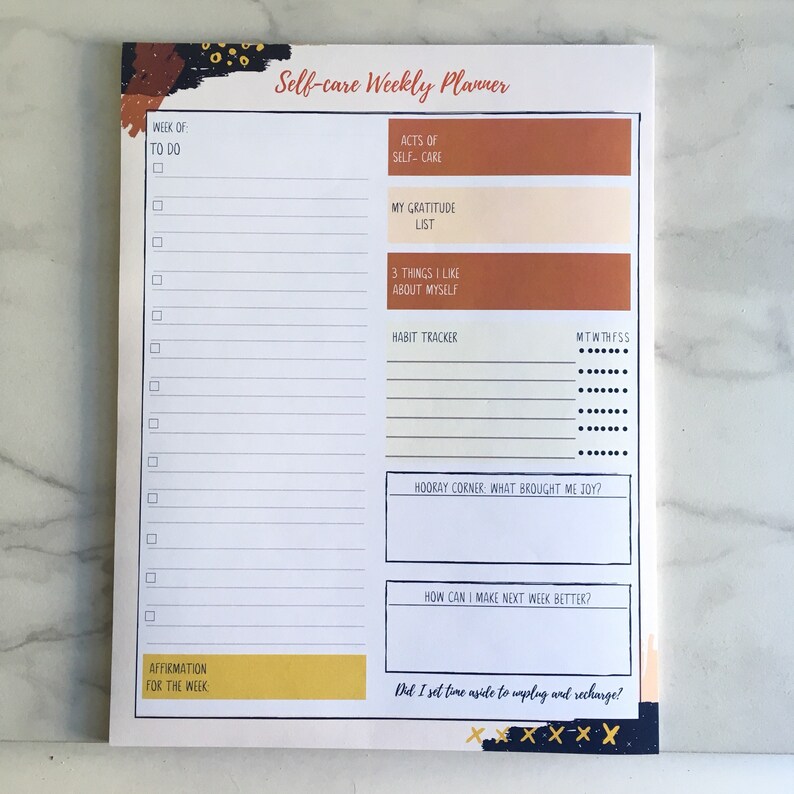 May include: A white self-care weekly planner with a brown and black abstract design. The planner includes sections for to-do lists, acts of self-care, gratitude, things you like about yourself, a habit tracker, a hooray corner, how to make next week better, and an affirmation for the week.