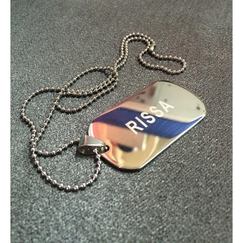 May include: A silver dog tag necklace with the name "Rissa" engraved on it.
