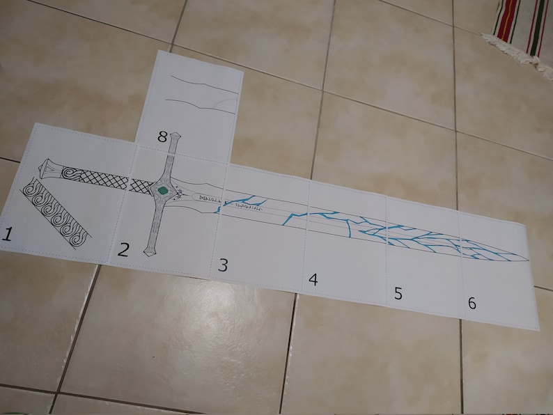 May include: A black and white sword design printed on eight separate sheets of paper. The sword has a blue and white pattern on the blade. The sheets are numbered 1 through 8.
