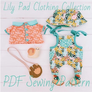 May include: Lily Pad Clothing Collection PDF Sewing Pattern featuring a peach patterned shirt with teal buttons, a floral bucket hat, floral overalls with teal straps, a felt snail, and a lily pad pendant on a polka dot ribbon strap.