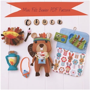 May include: A felt beaver doll wearing a headband with feathers and a bandana. The beaver is holding a camera and a backpack. The doll is surrounded by other felt items, including a campfire, a lantern, a canteen, and a sleeping bag.