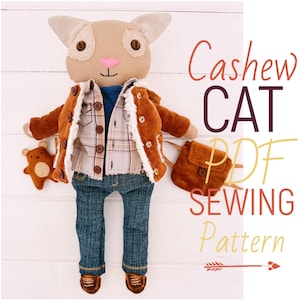 Puede incluir: Una muñeca de gato de peluche hecha a mano con una chaqueta de pana, una camisa a cuadros y vaqueros. El gato tiene ojos de botón y una nariz rosa. También se incluye un pequeño peluche de oso y una bolsa a juego. El texto "Cashew CAT PDF SEWING Pattern" es visible.