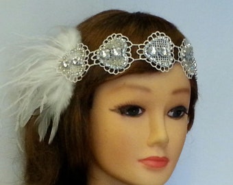 May include: A white feather headband with silver heart-shaped embellishments. The headband is made of delicate lace and features sparkling rhinestones.