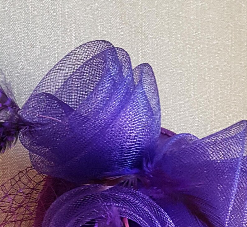 May include: A purple mesh bow with a layered design. The bow is made of a soft, delicate material and has a subtle shimmer.