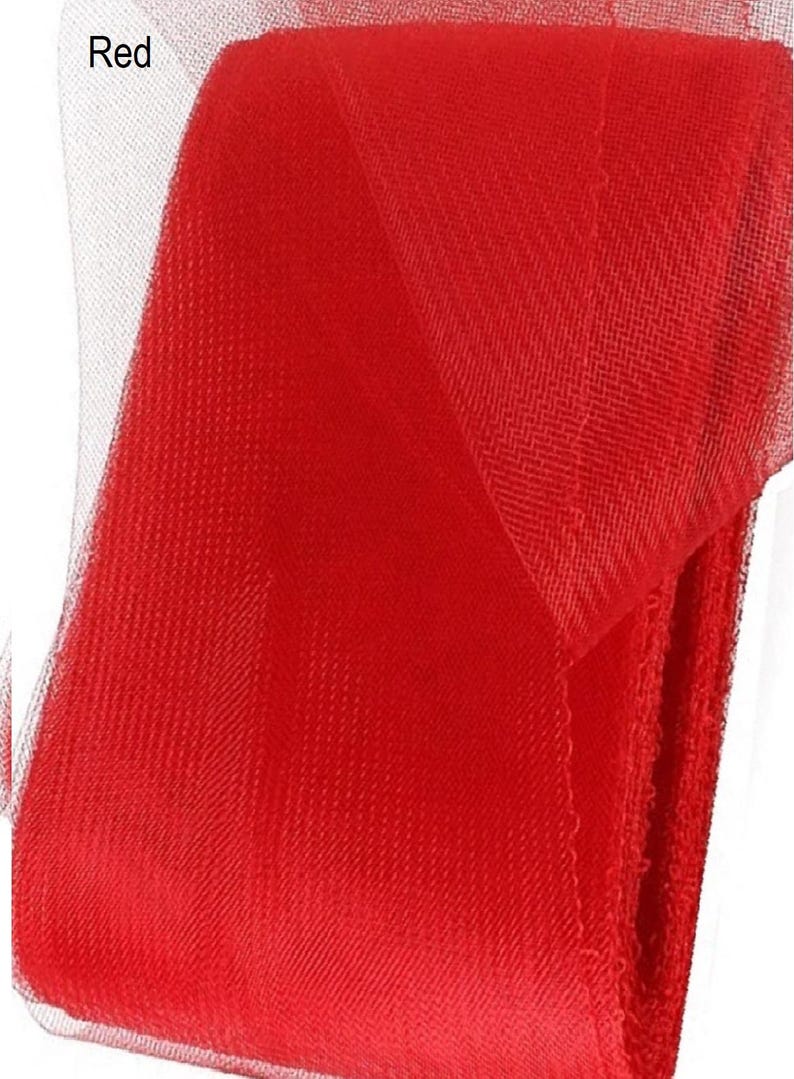 May include: Red tulle fabric, a sheer, lightweight material with a fine mesh texture. The fabric is folded in half, showing the red color and the mesh pattern.