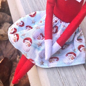 Puede incluir: Una falda de elfo azul y blanca con estampado de Pap&aacute; Noel. La falda tiene una cintura el&aacute;stica blanca y est&aacute; hecha de una tela suave de algod&oacute;n.