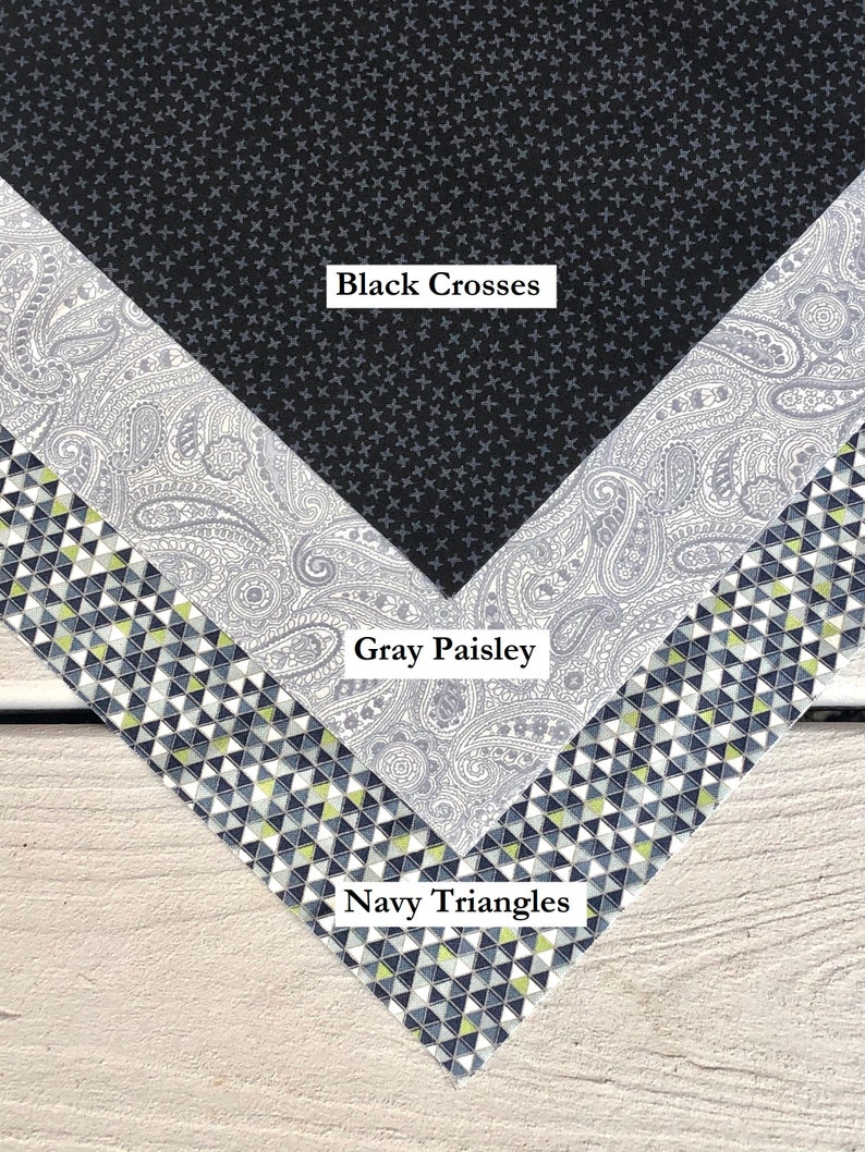 Pu&ograve; includere: Tre campioni di tessuto con diversi motivi. Il campione superiore &egrave; nero con piccole croci bianche. Il campione intermedio &egrave; grigio con un motivo paisley. Il campione inferiore &egrave; blu navy con piccoli triangoli bianchi e gialli.