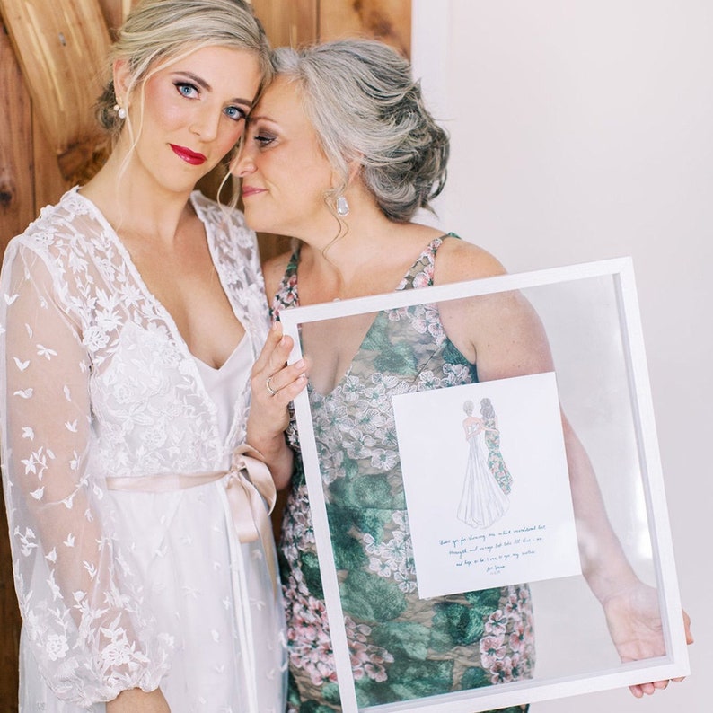 Custom illustration wedding drawing of mother of the bride and daughter in a back-facing style created with markers. This gift can be given on the wedding day morning or rehearsal dinner and includes a message from the bride or quote. Shown in frame.