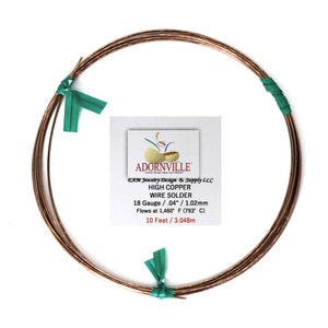 May include: A spool of 18 gauge, 0.04 inch, high copper wire solder. The wire is brown and is wrapped around a spool with green ties. The label on the spool reads "Adornville EAM Jewelry Design & Supply LLC High Copper Wire Solder 18 Gauge / .04" / 1.02mm Flows at 1,460° F (793° C) 10 Feet / 3.048m".