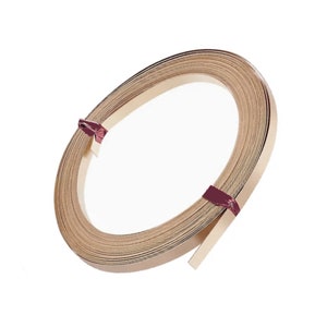 May include: A roll of brown wood veneer tape, tied with a burgundy ribbon. The tape is rolled into a circle and is ready to be used for woodworking projects.