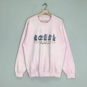 Può includere: Una felpa rosa con una grafica di fari e il testo "NOVA SCOTIA Lighthouses".
