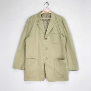 May include: A beige blazer with a button-up front and two patch pockets. The blazer has a classic, tailored fit.