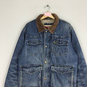 Puede incluir: Una chaqueta vaquera azul con cuello de pana marr&oacute;n y forro polar. La chaqueta tiene cierre de botones, dos bolsillos en el pecho y dos bolsillos grandes con solapa.