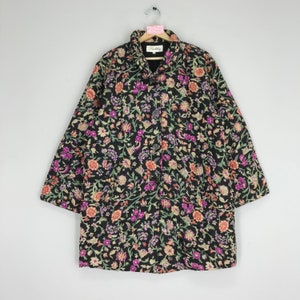 Puede incluir: Una chaqueta negra de manga larga con estampado floral en tonos rosa, naranja, verde y morado. La chaqueta tiene cierre de botón y dos bolsillos.