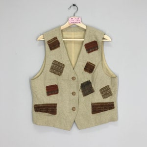 May include: A beige waistcoat with a brown, orange and black patterned design. The waistcoat has a button fastening and is made from a textured fabric.