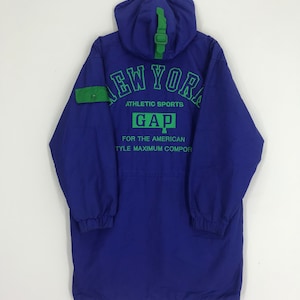 May include: A blue hooded jacket with green accents and the text "NEW YORK ATHLETIC SPORTS GAP FOR THE AMERICAN STYLE MAXIMUM COMFORT" printed on the back.