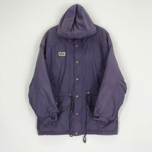 May include: A purple hooded jacket with a button-up front, drawstrings, and a small rectangular patch. The jacket has a relaxed fit and features pockets and adjustable cuffs. The jacket is made of a durable material.
