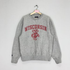 May include: Gray sweatshirt with a red Wisconsin logo and a badger mascot. The logo is in a vintage style with a red arch above the word "Wisconsin".