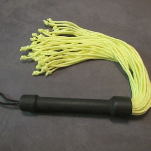 May include: A yellow rope whip with a black handle. The handle has a loop at the end for easy holding.