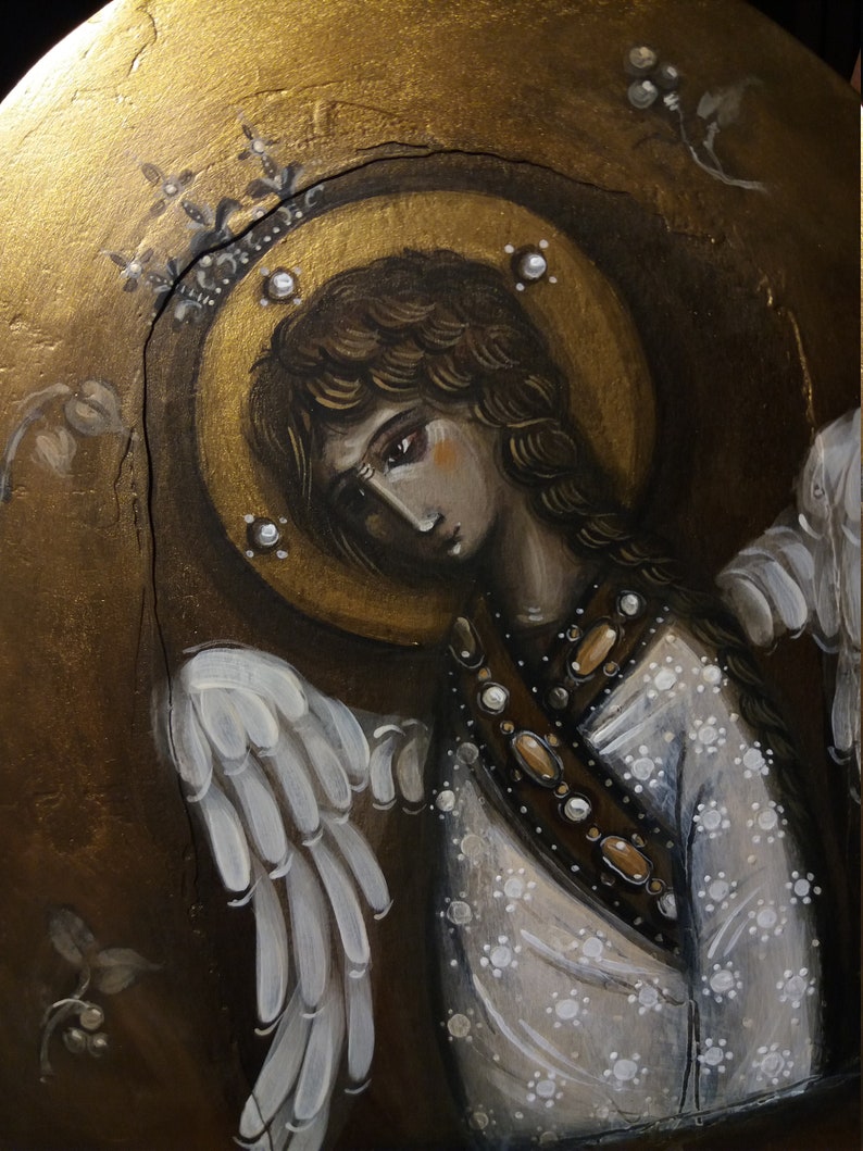 May include: A painting of an angel with white wings, a gold halo, and a white dress with gold accents. The angel has long brown hair and a sad expression.