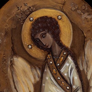 May include: A painting of an angel with brown hair and a halo. The angel is wearing a white robe with gold accents and has wings.