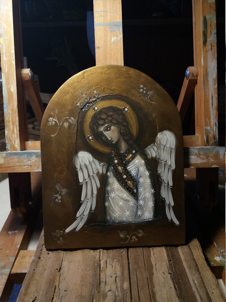 May include: A painting of an angel with white wings and a gold halo. The angel is wearing a white dress with gold accents and is holding a golden staff. The background is a gold and brown color.
