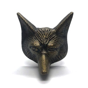 May include: A bronze-colored fox head door knob or pull. The fox has a detailed face with a pointed nose and small, dark eyes.