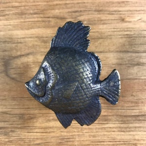 May include: A cast iron fish door knob with a dark bronze finish. The fish has a detailed design and a realistic appearance.