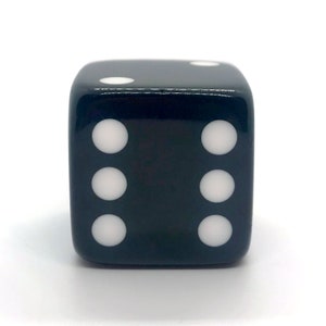 May include: A black six-sided die with white dots on each side. The die is showing the number four.