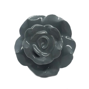 May include: A gray ceramic rose flower with a glossy finish. The rose has a three-dimensional design with multiple layers of petals.