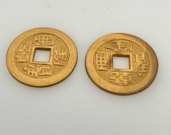 May include: Two gold-colored Chinese coins with a square hole in the center and Chinese characters on both sides.