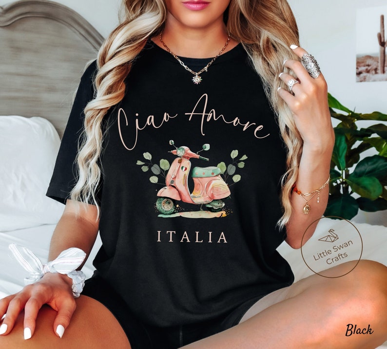 May include: Black t-shirt with a graphic of a pink scooter with the text "Ciao Amore ITALIA" printed on it.