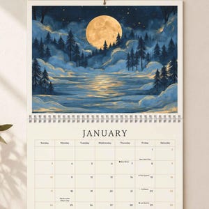 May include: A wall calendar for January featuring a top illustration of a full moon over a dark blue forest and a reflective lake. The calendar grid displays the days of the week, dates, and specific lunar phases including New Moon and Full Moon.