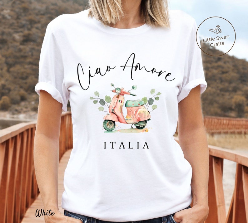 May include: White t-shirt with a black and white illustration of a pink scooter with the text "Ciao Amore ITALIA" printed on it.
