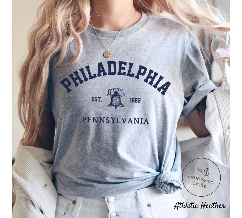 May include: Gray t-shirt with a blue graphic of the Liberty Bell and the text "PHILADELPHIA EST. 1682 PENNSYLVANIA".