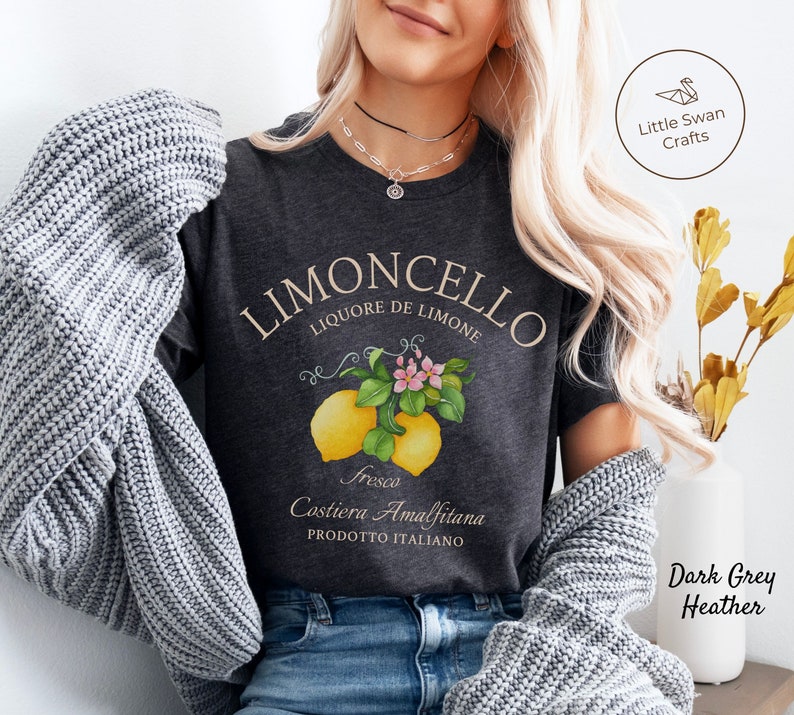 May include: Dark grey heather t-shirt with a vintage-style illustration of lemons and blossoms. The text "LIMONCELLO LIQUORE DE LIMONE" is printed in a white script font. The text "Fresco Costiera Amalfitana PRODOTTO ITALIANO" is printed in a smaller white font.
