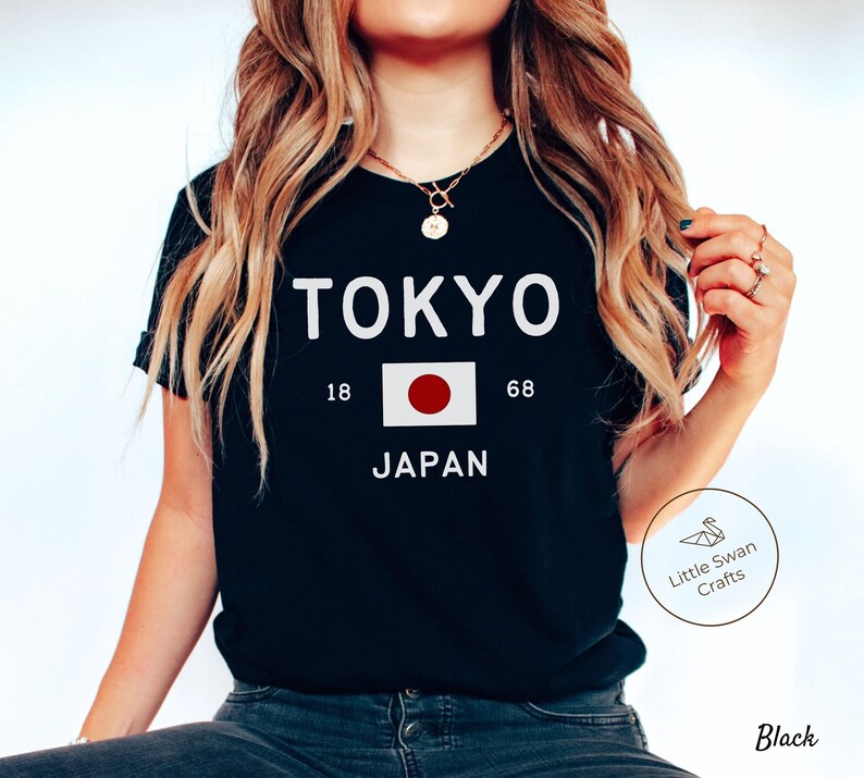 May include: Black t-shirt with white text that reads "TOKYO 18 68 JAPAN" and a red circle with a white circle in the center.